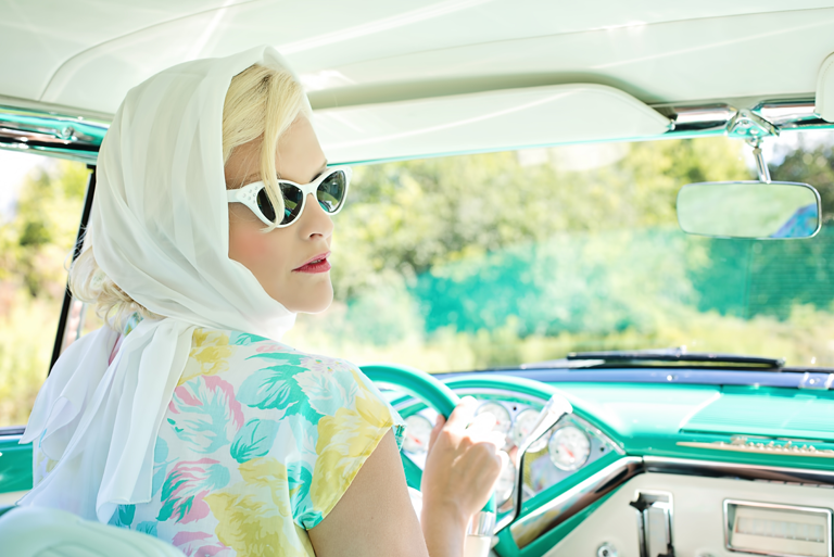 woman driving vintage car on road